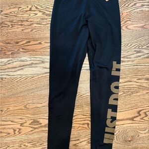 Nike Women’s black leggings with gold "Just Do It" logo. Size M
